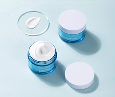 Two jars of ibcccndc hyaluronic acid cream moisturizer with a sample on a glass plate for hydrating skin
